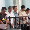 Bị cáo Lý Văn Đợi (áo trắng, thứ 3 từ trái qua) cùng đồng bọn nghe Tòa tuyên án. (Ảnh: Thanh Sang/TTXVN)