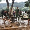 Các chiến sỹ tham gia dọn dẹp bùn đất tại trường học ở Mù Cang Chải. (Ảnh: Đinh Hữu Dư/TTXVN)