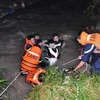 Lực lượng cứu hộ, cứu nạn tỉnh Đồng Nai đưa chiếc xe máy lên bờ và tiếp tục tham gia tìm kiếm người đàn ông mất tích do lũ cuốn trôi trong đêm. (Ảnh: Sỹ Tuyên/TTXVN)