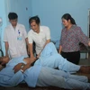 Lãnh đạo Ủy ban Nhân dân huyện Vị Xuyên thăm hỏi các bệnh nhân trong vụ ngộ độc. (Ảnh: Minh Tâm/TTXVN)