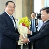Chủ tịch tỉnh Bình Dương Trần Thanh Liêm (phải) tặng hoa chúc mừng Phó Thủ tướng Lào Sonexay Siphandone. (Ảnh: Nguyễn Văn Việt/TTXVN)
