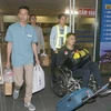 Ba thuyền viên Bùi Xuân Viện (áo xanh), Bùi Trung Đức (áo đen ngồi xe)và Nguyễn Quang Huy (hàng sau) về đến Sân bay quốc tế Nội Bài. (Ảnh: Doãn Tấn /TTXVN)
