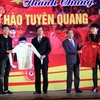 Hai tuyển thủ U23 Lương Xuân Trường, Nguyễn Thành Trung tặng chiếc áo đấu có chữ ký cho lãnh đạo tỉnh Tuyên Quang. (Ảnh: Quang Cường/TTXVN)