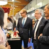 Đại sứ Việt Nam tại Vương quốc Bỉ Vương Thừa Phong (phải) thăm gian hàng Việt Nam. (Ảnh: Kim Chung/TTXVN)