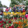 Người dân đi mua sắm hoa tết chiều 30 Tết. (Ảnh: Trần Thị Thu Hiền/TTXVN)