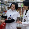Bác sỹ Cầm Thị Hương (bên phải) bên cạnh nhiều loại thuốc quý của các dân tộc vùng Tây Bắc được Bệnh viên Y học cổ truyền tỉnh Sơn La sử dụng điều trị cho bệnh nhân. (Ảnh: Diệp Anh/TTXVN)