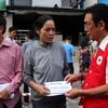 Đại diện Trung ương Hội Chữ thập Đỏ Việt Nam trao hỗ trợ cho gia đình nạn nhân. (Ảnh: Xuân Dự/TTXVN)