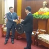 Bí thư Tỉnh ủy Hòa Bình Bùi Văn Tỉnh trao tặng chiếc chiêng Mường, sản phẩm văn hóa đặc sắc của Hòa Bình cho ông Saysomphone Phomvihane. (Ảnh: Nhan Sinh/TTXVN)