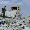 Một binh sỹ Syria quay phim lại cảnh đổ nát sau cuộc không kích của liên quân. (Nguồn: abc.net.au)