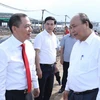 Thủ tướng Nguyễn Xuân Phúc trao đổi với ông Phạm Nhật Vượng, Chủ tịch Hội đồng quản trị Tập đoàn Vingroup tại khu vực hạng mục đang được xây dựng của Nhà máy ôtô Vinfast. (Ảnh: Thống Nhất/TTXVN)