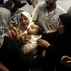 Người thân đau buồn trước cái chết của em bé 8 tháng tuổi Leila al-Ghandour thiệt mạng trong cuộc xung đột tại Gaza ngày 13/5. (Nguồn: AFP/TTXVN)