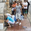 Người dân xếp hàng chờ lấy nước từ mạch nước ngầm tại St. James, Cape Town, Nam Phi ngày 19/1. (Nguồn: AFP/TTXVN)
