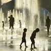 Trẻ em chơi đùa bên vòi phun nước để tránh nắng nóng tại Montreal, Canada ngày 3/7. (Nguồn: AFP/TTXVN)