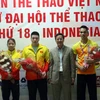 Đại sứ Phạm Vinh Quang chúc mừng 3 vận động viên giành huy chương vàng. (Ảnh: Trần Chiến/Vietnam+)