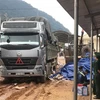 Số gỗ được giấu kín trong những kiện hàng phế liệu được các xe tải kéo rơmóc chở từ Lào về Việt Nam. (Ảnh: Thanh Thủy/TTXVN)