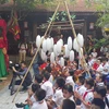 Các học sinh xem trình diễn rối cạn Tế Tiêu, huyện Mỹ Đức, Hà Nội tại phố cổ Hà Nội. (Ảnh: Đinh Thuận/TTXVN)
