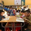 Học sinh tại điểm trường Bản Xèo, huyện Bát Xát đọc sách do Đoàn Thanh niên Thông tấn xã Việt Nam trao tặng. (Ảnh: Quốc Khánh/TTXVN)
