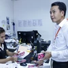 Nhân viên của Công ty Unitel, liên doanh Viễn thông giữa giữa Viettel và Lao Asia Telecom mua hàng trăm vé cho các cán bộ công nhân của Công ty tại Liên đoàn Bóng đá Lào. (Ảnh: Phạm Kiên/TTXVN)
