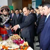 Thủ tướng Nguyễn Xuân Phúc xem các gian hàng trưng bày sản phẩm tại hội nghị. (Ảnh: Thống Nhất/TTXVN)