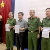 Đại tá Lê Ngọc Phương, Cục phó Cục Cảnh sát hình sự, đại diện Bộ Công an trao quyết định khen thưởng cho các đơn vị tham gia phá án. (Ảnh: Nguyễn Văn Việt/TTXVN)