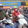 Người dân Hà Nội ra đường đều trang bị cho mình quần áo ấm, quấn khăn, đeo khẩu trang… để chống lại thời tiết lạnh buốt nhất là khi di chuyển bằng xe máy. (Ảnh: Quang Quyết/TTXVN)