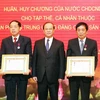 Ông Bosengkham Vongdara, Bộ trưởng Bộ Thông tin, Văn hoá và Du lịch Lào trao tặng Huân chương Lao động hạng Nhất và hạng Nhì của Chủ tịch nước Lào cho hai cá nhân của Văn phòng Trung ương Đảng. (Ảnh: Nguyễn Dân/TTXVN)