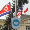 Cờ Mỹ và cờ Triều Tiên, bên dưới là biểu tượng hai bàn tay bắt chặt vào nhau thể hiện tinh thần của cuộc gặp lớn, được treo bên ngoài Nhà khách Chính phủ trên phố Ngô Quyền, Quận Hoàn Kiếm. (Ảnh: Lâm Khánh/TTXVN)