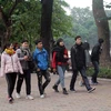 Người dân tại Hà Nội dạo chơi trên phố đi bộ hồ Hoàn Kiếm đều trang bị cho mình quần áo ấm, quấn khăn, đeo khẩu trang… để chống lại thời tiết lạnh buốt. (Ảnh: Quang Quyết/TTXVN)