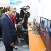 Thủ tướng Nguyễn Xuân Phúc kiểm tra khu vực tác nghiệp của Thông tấn xã Việt Nam tại Trung tâm Báo chí quốc tế. (Nguồn: TTXVN)