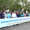 Thủ tướng Nguyễn Xuân Phúc và các đại biểu cùng tham gia đi bộ trên đường Đinh Tiên Hoàng, hưởng ứng Năm an toàn cho phụ nữ và trẻ em. (Ảnh: Thống Nhất/TTXVN)