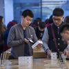 Người dân mua điện thoại iPhone của Apple tại cửa hàng ở Bắc Kinh, Trung Quốc. (Nguồn: AFP/TTXVN)