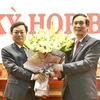Ông Bùi Minh Châu (phải), Bí thư tỉnh ủy Phú Thọ, tặng hoa chúc mừng ông Bùi Văn Quang. (Ảnh: Trung Kiên/TTXVN)