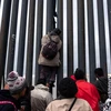 Người di cư Trung Mỹ trèo qua bức tường biên giới Mỹ-Mexico tại Playas de Tijuana, bang Baja California, Mexico, ngày 21/3/2019. (Nguồn: AFP/TTXVN)