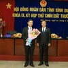 Ông Trần Văn Nam (bên phải), Bí thư Tỉnh ủy tặng hoa chúc mừng ông Võ Văn Minh. (Nguồn: baobinhduong.vn)