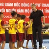 Huyền thoại Manchester United bắt tay với các cầu thủ nhí của câu lạc bộ bóng đá học đường huyện Thạch Hà, Hà Tĩnh. (Ảnh: Phan Quân/TTXVN)