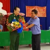 Đại diện Viện Kiểm sát Nhân dân tỉnh Tây Ninh tặng hoa xin lỗi ông Nguyễn Văn Dũng. (Ảnh: Lê Đức Hoảnh/TTXVN)