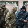 Nhân viên mật vụ thuộc Cơ quan An ninh Liên bang Nga áp giải một thủy thủ Ukraine (phải) bị bắt tới tòa án ở Simferopol, Bán đảo Crimea ngày 27/11/2018. (Nguồn: AFP/ TTXVN)