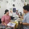 Đại sứ Bai Tian đưa cho chủ nhà hàng xem chiếc điện thoại Huawei của mình để nhận được giảm giá. (Nguồn: Facebook Đại sứu quán Trung Quốc ở Malaysia)