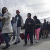 Người di cư Trung Mỹ vượt qua hàng rào biên giới khi di chuyển từ Tijuana, bang Baja California (Mexico) tới San Diego, Mỹ, ngày 21/3/2019. (Nguồn: AFP/TTXVN)