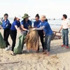 Hoa hậu Tiểu Vy và các đoàn viên thanh niên cùng người dân địa phương chung tay làm sạch bờ biển Cảnh Dương với các hoạt động như dọn dẹp, thu gom rác thải trên bãi biển. (Ảnh: Võ Dung/TTXVN)