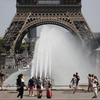 Người dân giải nhiệt tránh nóng tại một đài phun nước ở Paris, Pháp ngày 29/6/2019. (Nguồn: AFP/TTXVN)