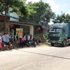 Người dân khu 1 và khu 2 xã Trạm Thản ra chặn đường không cho xe chở rác lưu thông. (Ảnh: Trung Kiên/TTXVN)