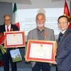 Phó Chủ tịch Quốc hội Phùng Quốc Hiển trao tặng Huân chương Hữu nghị cho ông Diego Vecchiato, Giám đốc truyền thông và quan hệ quốc tế Vùng Veneto và ông Carlo Coccato, thành viên Liên đoàn lao động Vùng Veneto. (Ảnh: Ngự Bình/TTXVN)