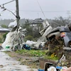 Một công nhân đứng giữa chụp ảnh những mảnh vỡ sau cơn bão Hagibis quét qua Ichihara, Chiba, gần Tokyo. (Nguồn: AP)
