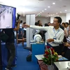 Các đại biểu tham quan các gian hàng trưng bày sản phẩm công nghệ số. (Ảnh: Quốc Dũng/TTXVN)
