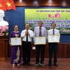 Chủ tịch Ủy ban Nhân dân tỉnh Sóc Trăng tặng bằng khen cho nhóm lai tạo giống lúa. Ảnh: Trung Hiếu/TTXVN)