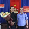 Đại diện Viện Kiểm sát nhân dân thành phố Nha Trang tặng hoa cho ông Thái Xuân Đàn trong buổi xin lỗi sáng 24/12. (Ảnh: Nguyễn Dũng/TTXVN)