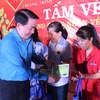 Ông Kiều Ngọc Vũ, Phó Chủ tịch Liên đoàn Lao động Thành phố Hồ Chí Minh trao vé xe về quê ăn Tết cho công nhân. (Ảnh: Xuân Anh/TTXVN)