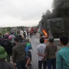 Cảnh sát phòng cháy nỗ lực dập tắt xe ôtô bị cháy trên đường tránh thành phố Vinh đoạn qua xã Nghi Diên, huyện Nghi Lộc, Nghệ An. (Ảnh: Nguyễn Văn Nhật/TTXVN)