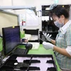 Người lao động tại Công ty trách nhiệm hữu hạn Samsung Electronics Việt Nam đeo khẩu trang và sử dụng các biện pháp phòng chống dịch viên đường hô hấp cấp COVID-19. (Ảnh: Anh Tuấn/TTXVN)